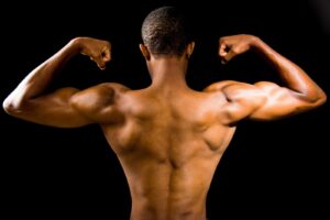 man flexing his muscles with black background